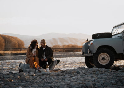 A couple enjoying The Better Half Wines by a wild river in New Zealand